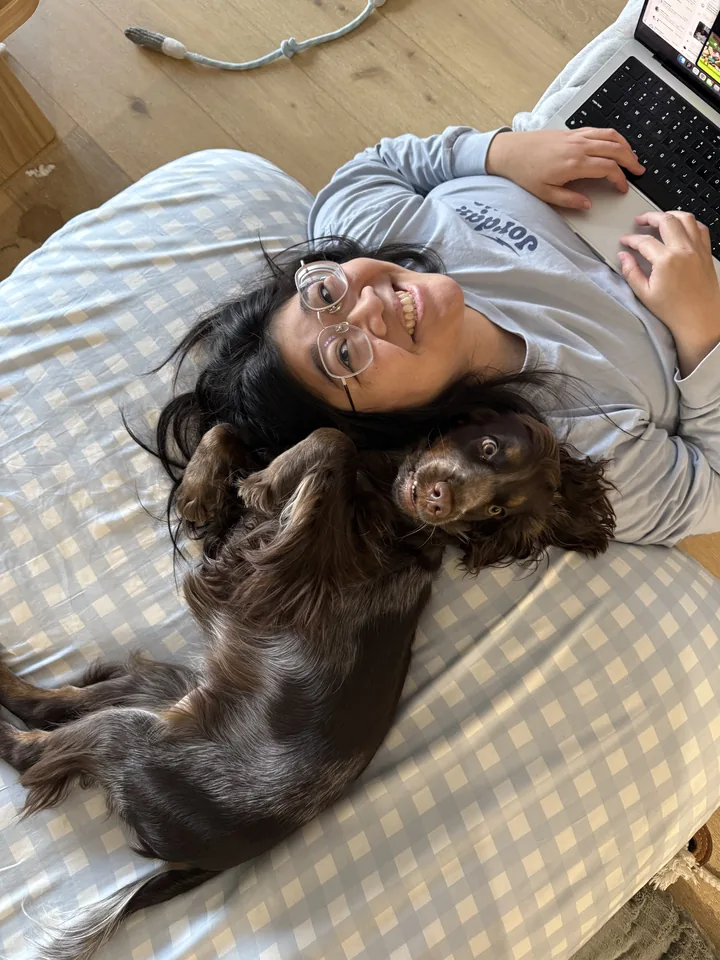 One of Olive's owners lying with her on a beanbag