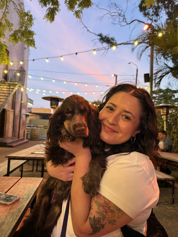 Another of Olive's owners holding her at a beer garden